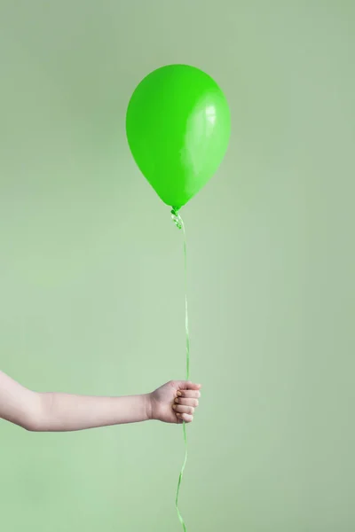 hand holding single green balloon