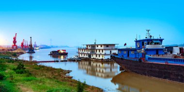Yangtze Nehri üzerinde konteyner terminali, gece görüş kargo gemileri ve vinç.