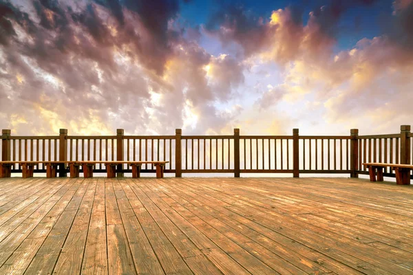 Wooden flooring and sunset/sunrise with clouds, light and other atmospheric effects.