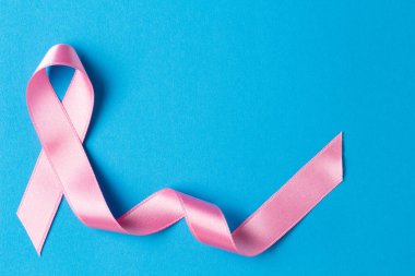 Pink ribbon on a blue background.Breast cancer. clipart