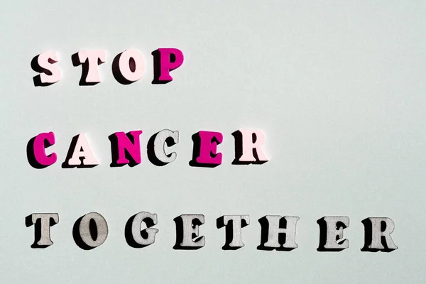 STOP CANCER TOGETHER woord en roze lint op grijze achtergrond. — Stockfoto