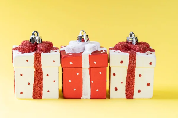 Sarı arka planda beyaz ve kırmızı Noel süslemesi. Hediye Noel süslemesi.