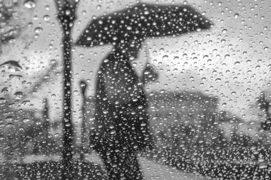 mavi şemsiye, vintage tutan adamdan arka plan bulanık cam üzerinde yağmur damlaları