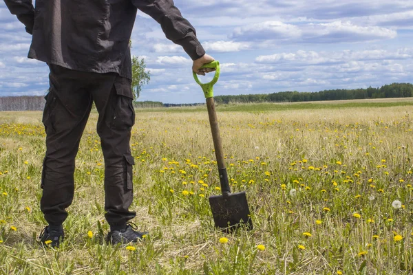 Bakire arazi ortasında duran bir alanı çıkarmak bir düşünceli adam, bir kürek ile