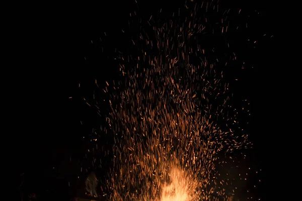 Falò scintilla nel cielo buio di notte, fuoco superficiale — Foto Stock