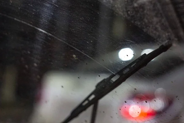 ワイパー汚れた傷フロント ガラスの車の中 夜の雨の季節 フロントとバックの背景のボケ効果でぼやけています — ストック写真