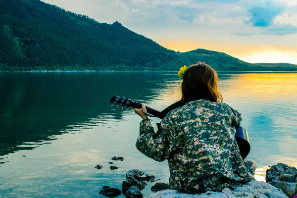 Sylwetka Dziewczyna Zachodzie Słońca Grając Gitarze Rzeki — Zdjęcie stockowe