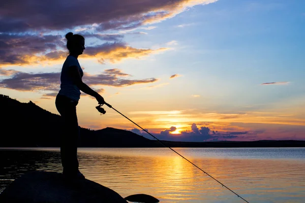 Mom and her little daughter are fishing with a fishing rod on a — Stock Photo, Image