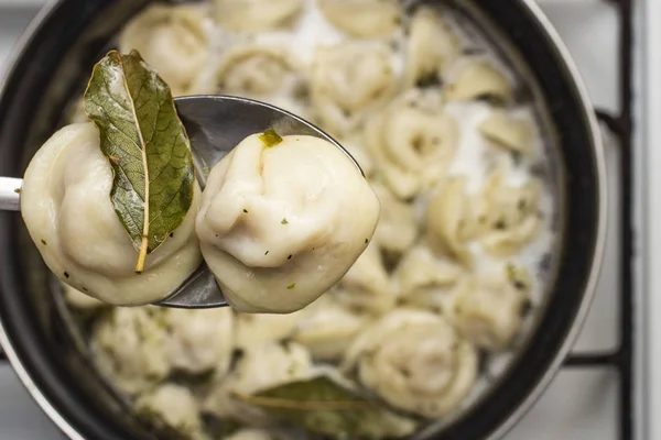 meat dumplings are boiled in a pot of boiling water