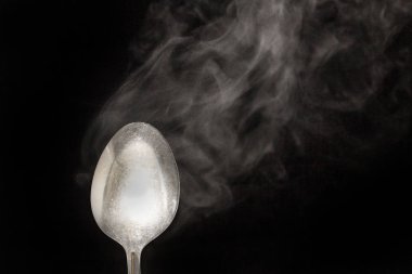 sıcak çelik kaşık su buhar siyah zemin üzerine