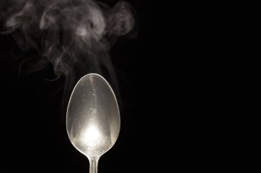 sıcak çelik kaşık su buhar siyah zemin üzerine