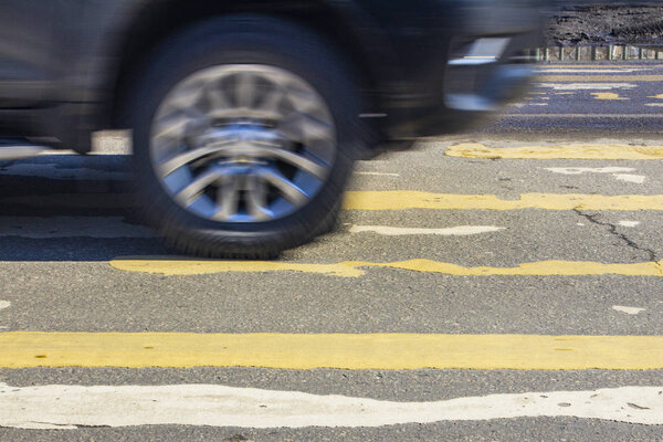 движущиеся транспортные средства в размытом виде, и люди на стёртом кресте
