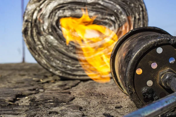 Gasbrander met vuur en rol van dakbedekking materiaal op wazig BAC — Stockfoto