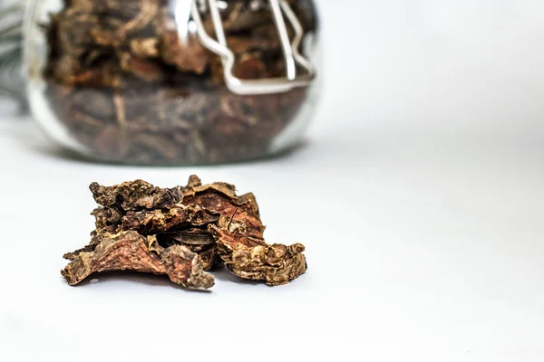 Cut dry root of Rhodiola rosea in a glass jar on natural white b — Stock Photo, Image