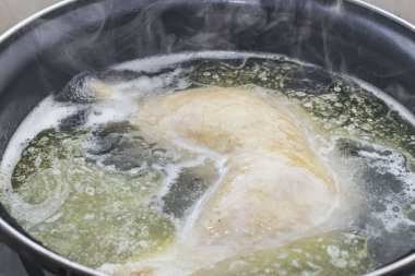 bulanık arka plan ile bir tencerede suyu yakın çekim haşlanmış tavuk bir