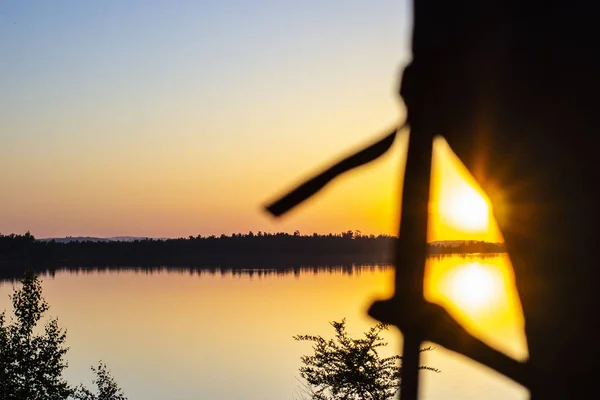 Tente d'arc floue au premier plan d'un coucher de soleil et un lac dans le — Photo