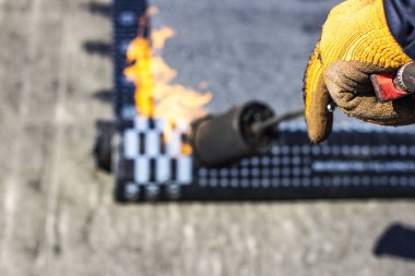 Construc sırasında propan blowtorch ile Rulo çatı Kurulumu