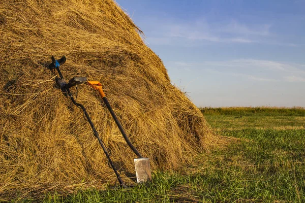 金属探测器和树苗铲在露天的干草堆 — 图库照片