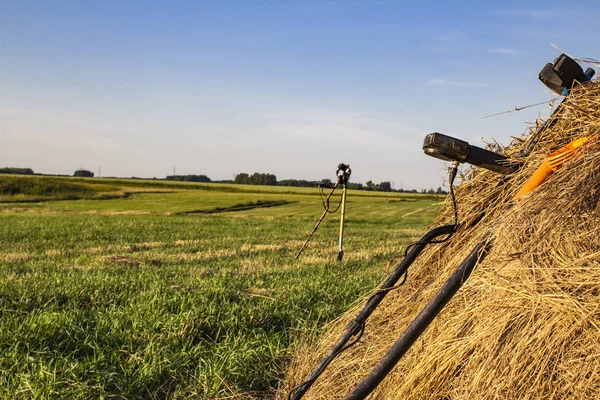 metal detector and sapper shovel on a haystack in an open field