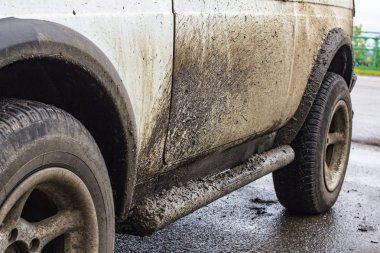 Arabanın tekerleklerinden sınıf kiri. Beyaz bir arabaya yapışın Due 
