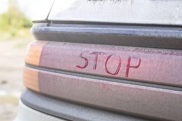 A felirat "stop" a piszkos féklámpa az autó, páfrány — Stock Fotó