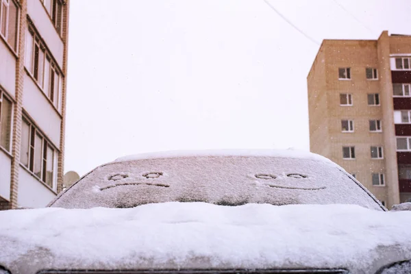 Happy and sad smiley emoticon face in snow on car windows, winte