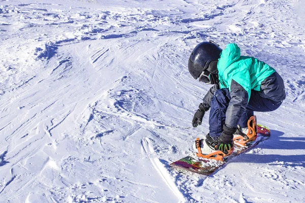 Kinderen leren snowboarden op de berghelling op een heldere dag — Stockfoto