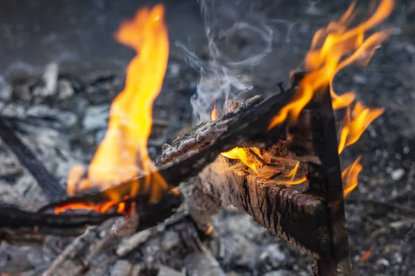 Verbrannter Zaun in Großaufnahme auf der Asche eines großen Feuers, auf einem verschwommenen — Stockfoto