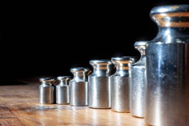 Mücevher pulları için ahşap bir masanın üzerindeki küçük ağırlıklar. ön ve arka plan bokeh etkisi ile bulanıklaştırıldı