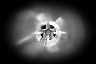 Arka plandaki egzoz vantilatöründeki galvanize çelik hava kanalının içerisinden yakın çekim görüntüsü Bokeh etkisi ile ön ve arka plan bulanıklaşır.