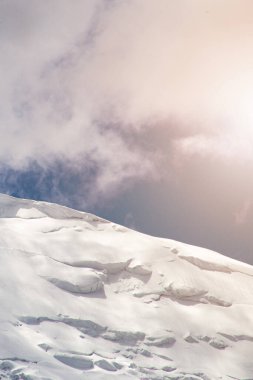 Kötü havada bir dağın zirvesine yakın çekim, rüzgarlı havada dağcıların ölümüne yol açar, bulutlardaki karlı zirveler