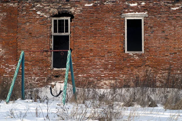 在冬天的建筑物废墟旁边即兴自制的秋千 — 图库照片