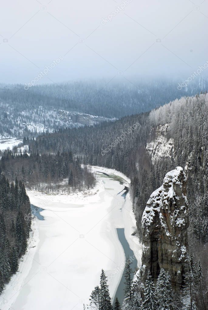 Winter view of the rock Devil`s Finger and the river Usva from the rock Stolby (