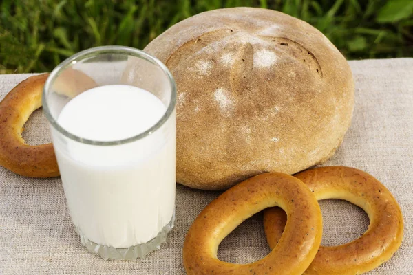 Glas Mit Milch Bagels Und Rustikalem Brot Auf Einer Leinentischdecke — Stockfoto