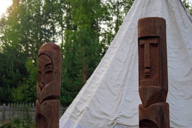 geleneksel çadır (Oda arkadaşı veya tipi) portre bir orman yakın çekim arka plan önünde iki dinsiz ahşap totemler