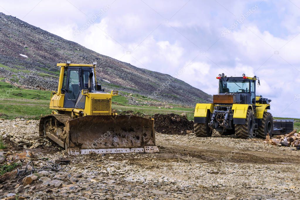 heavy machinery two bulldozers on the construction of roads in the mountains