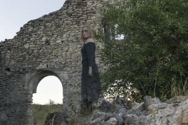 bir harap antik buildin ortasında siyah elbiseli yarı saydam bir kız harabelerde - hayalet