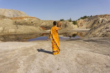 bir kız ile bir sürahi omzuna bir sari su için ıssız bir manzara kirli göle gider