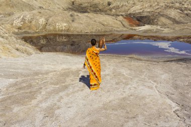 bir kız ile bir sürahi omzuna bir sari su için ıssız bir manzara kirli göle gider