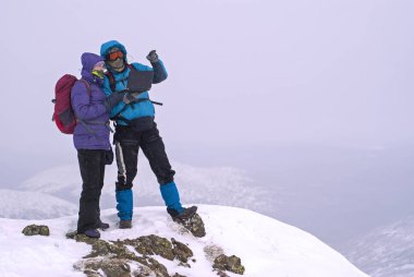 bir dizüstü bilgisayar ile bir kış dağ tepe üzerinde iki yürüyüşçü