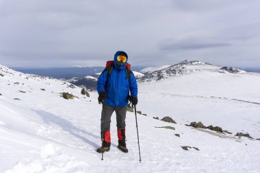 dağcı ayna rüzgar geçirmez bardaklarda ve kış dağ manzarası bir arka plan üzerinde bir sırt çantası ile windproof maskesi