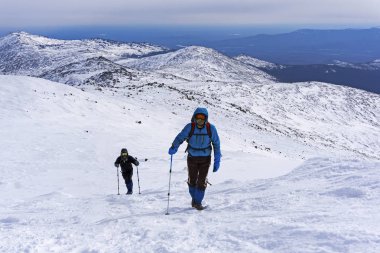 iki dağcı gider kadar karla kaplı dağ yamacı