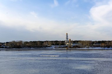 bir çan kulesi kadar banka ile bir geniş nehir buz ve Ortodoks Kilisesi üzerinde kayan ile bahar manzara