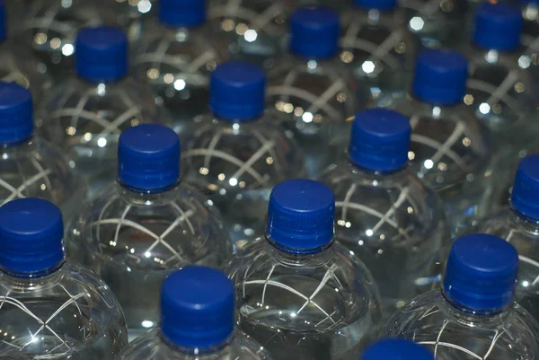 Fondo Botellas Plástico Con Agua Potable Con Tapones Azules — Foto de Stock