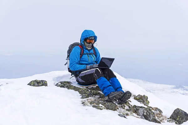 Gezgin serbest meslek ile bir dizüstü bilgisayar içinde belgili tanımlık kış medeniyet uzak vahşi dağlarda çalışıyor
