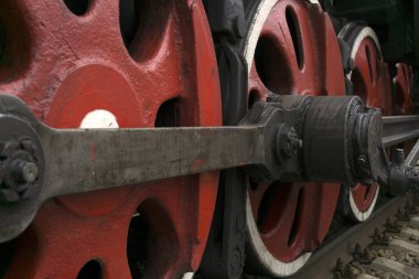 wheels of an old functioning steam locomotive with drawbar and crank mechanism closeup clipart
