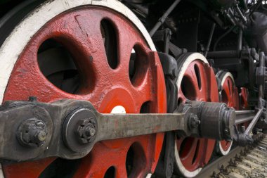 wheels of an old functioning steam locomotive with drawbar and crank mechanism closeup clipart