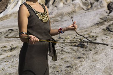bir kadın bulma yöntemi tarafından bir çöl bölgesinde su arar; Sadece onun Gövde ve kollar görünür.