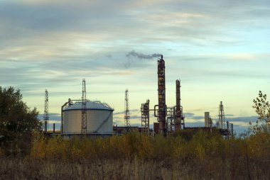 Endüstriyel yatay sütunlar parçalanması ve petrol ürünleri akşam gökyüzü altında depolamak için bir tank çalışma-