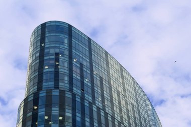 top karşı akşam gökyüzünde uçan bir kuş ile modern bir ofis ve cam cephe
